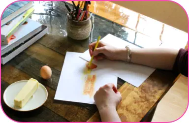 Director of Khlabeth Books using colored pencils to draw butter and eggs