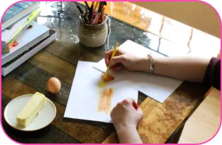 Director of Khlabeth Books using colored pencils to draw butter and eggs